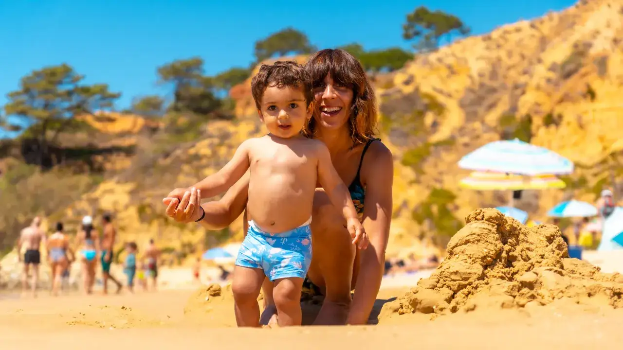 Sonnige Tage an der Algarve mit Kindern: Ein kleines Kind und seine Mutter genießen den Sandstrand.