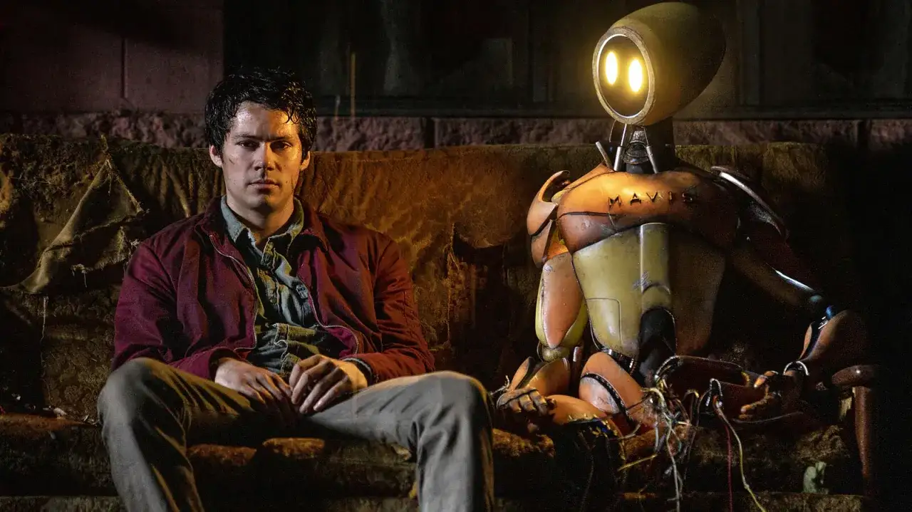 Ein Mann und ein Roboter namens MAVIS sitzen auf einer Couch. Eine ungew&ouml;hnliche Freundschaft, die zeigt, dass Liebe auch zwischen Menschen und Monstern entstehen kann.