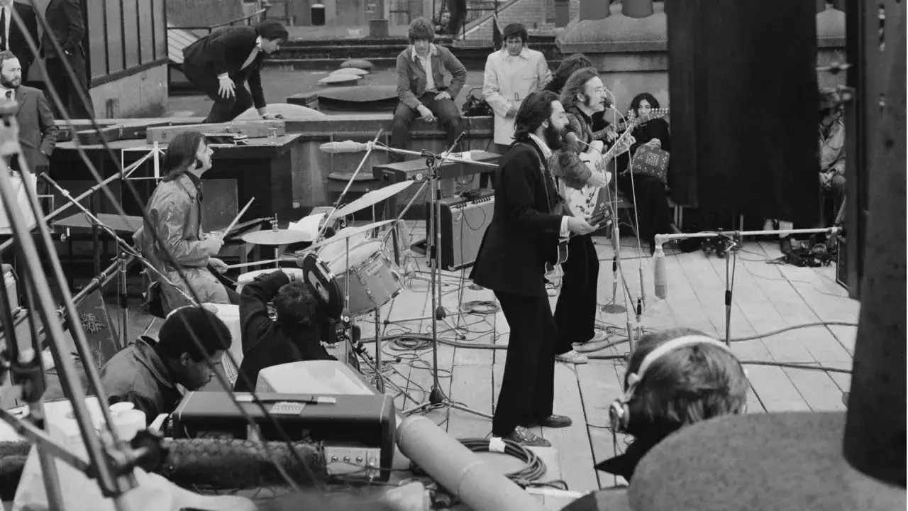 The Beatles grają na dachu. Ciekawostki z tego legendarnego koncertu: Ringo Starr za perkusją, John Lennon i Paul McCartney z gitarami.