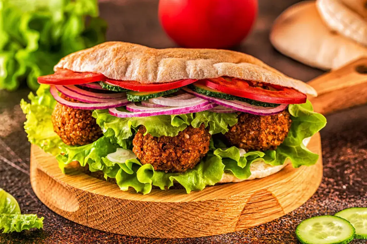 Pyszny falafel w picie z sałatą, pomidorem, ogórkiem i czerwoną cebulą. Idealna przekąska, która odpowie na pytanie: co to jest falafel?