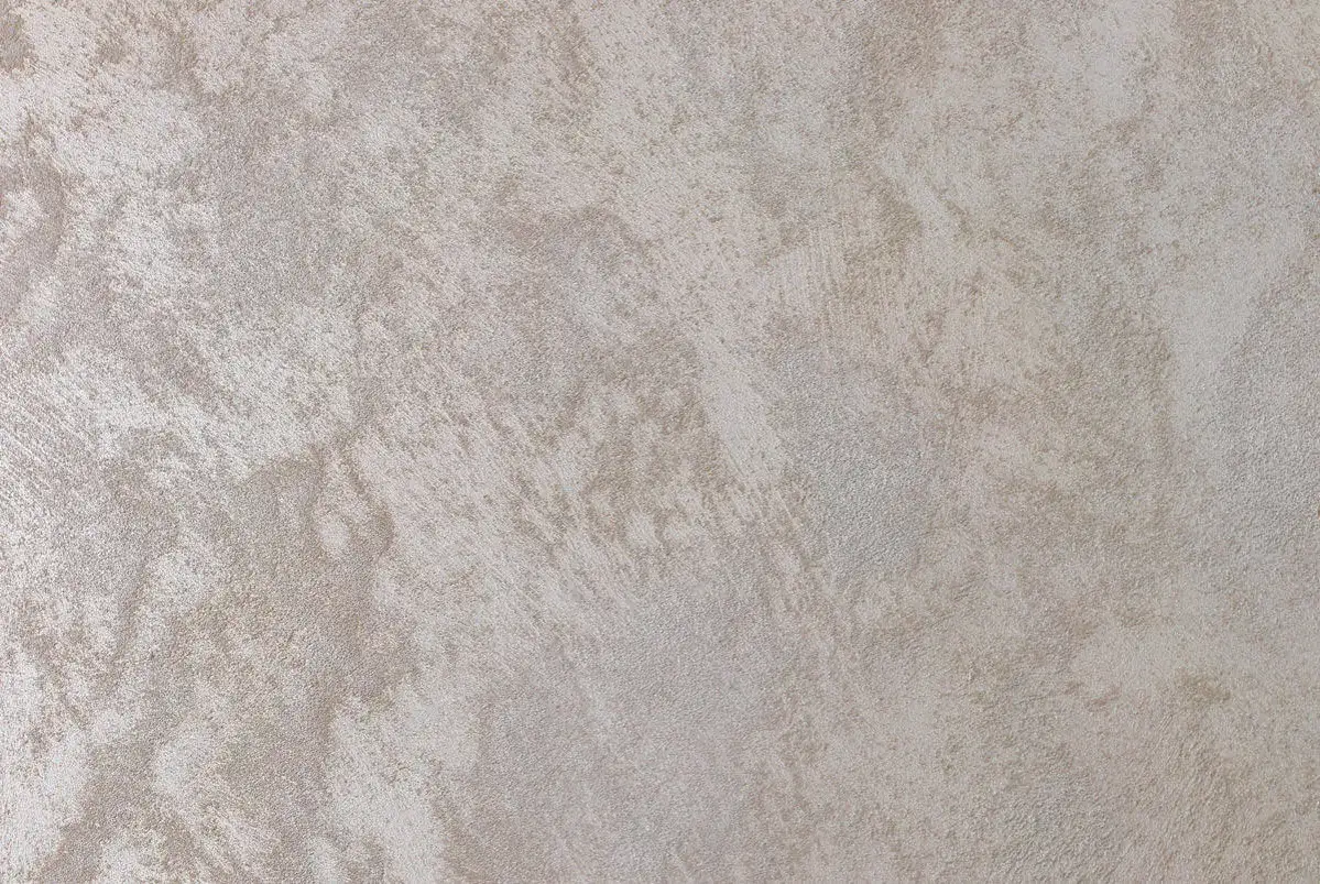 Superficie di un muro con un elegante effetto spugnato, che ricorda la texture di un tessuto pregiato.