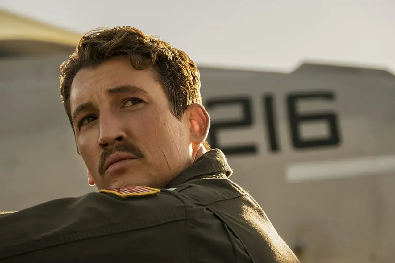 Miles Teller, pilota nel film, con un aereo sullo sfondo.