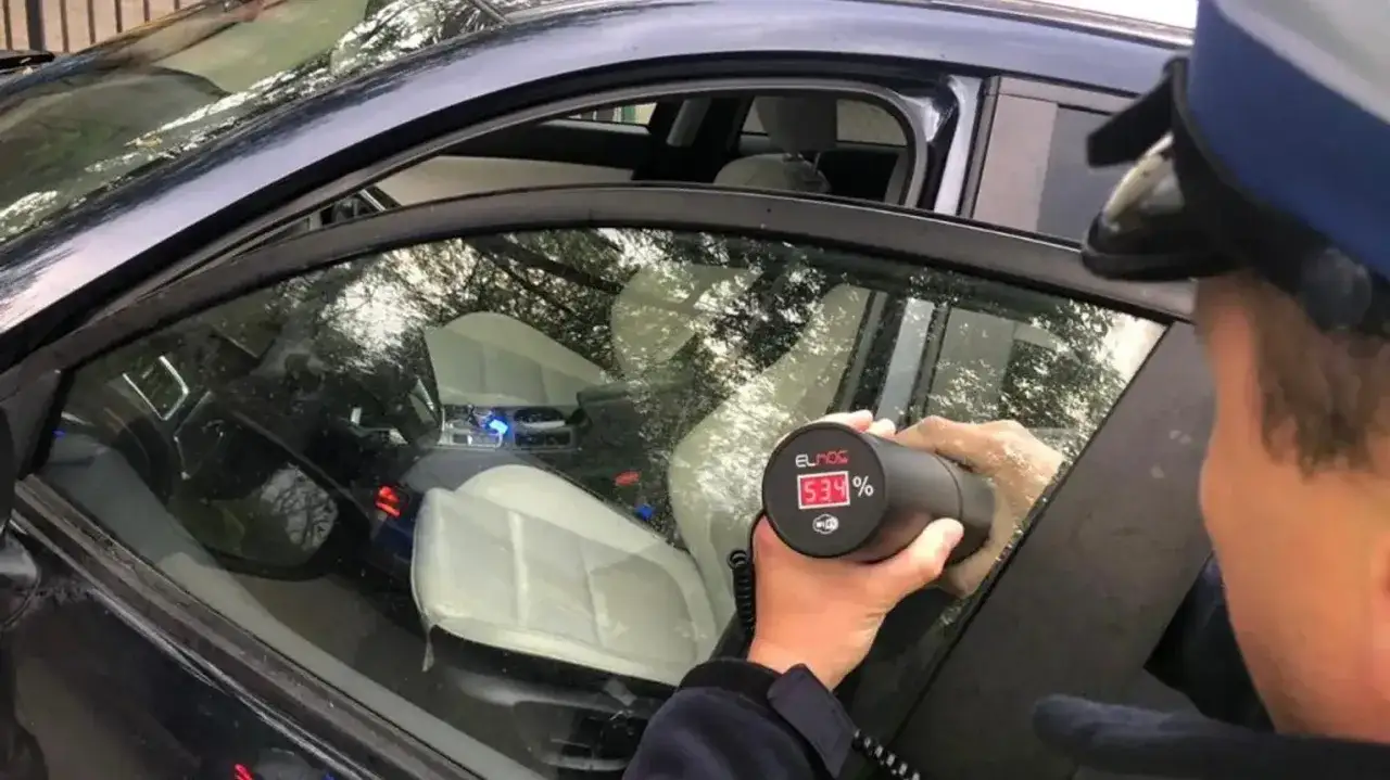 Policjant mierzy przyciemnienie szyb. Wynik 53,4% może oznaczać mandat za przyciemnione szyby.