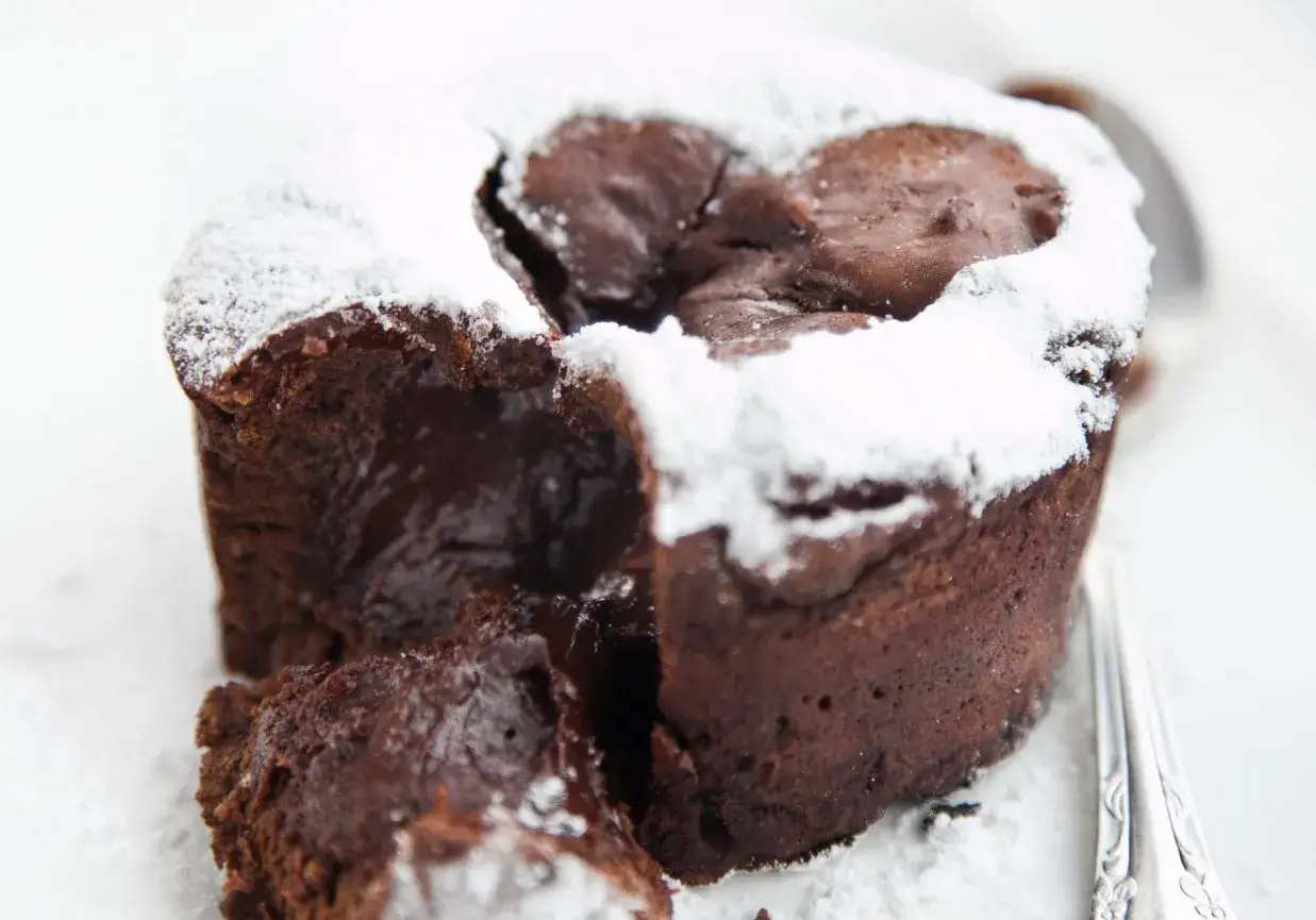 Czekoladowe ciasto brownie z płynną czekoladą w środku, posypane cukrem pudrem. Idealne na deser.