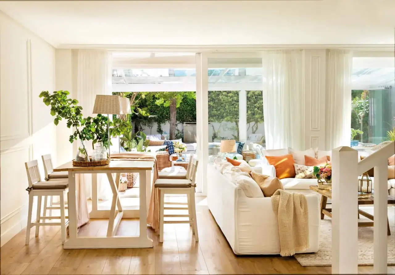 Ideas para un salón comedor luminoso con sofá blanco, mesa alta y vistas al jardín.