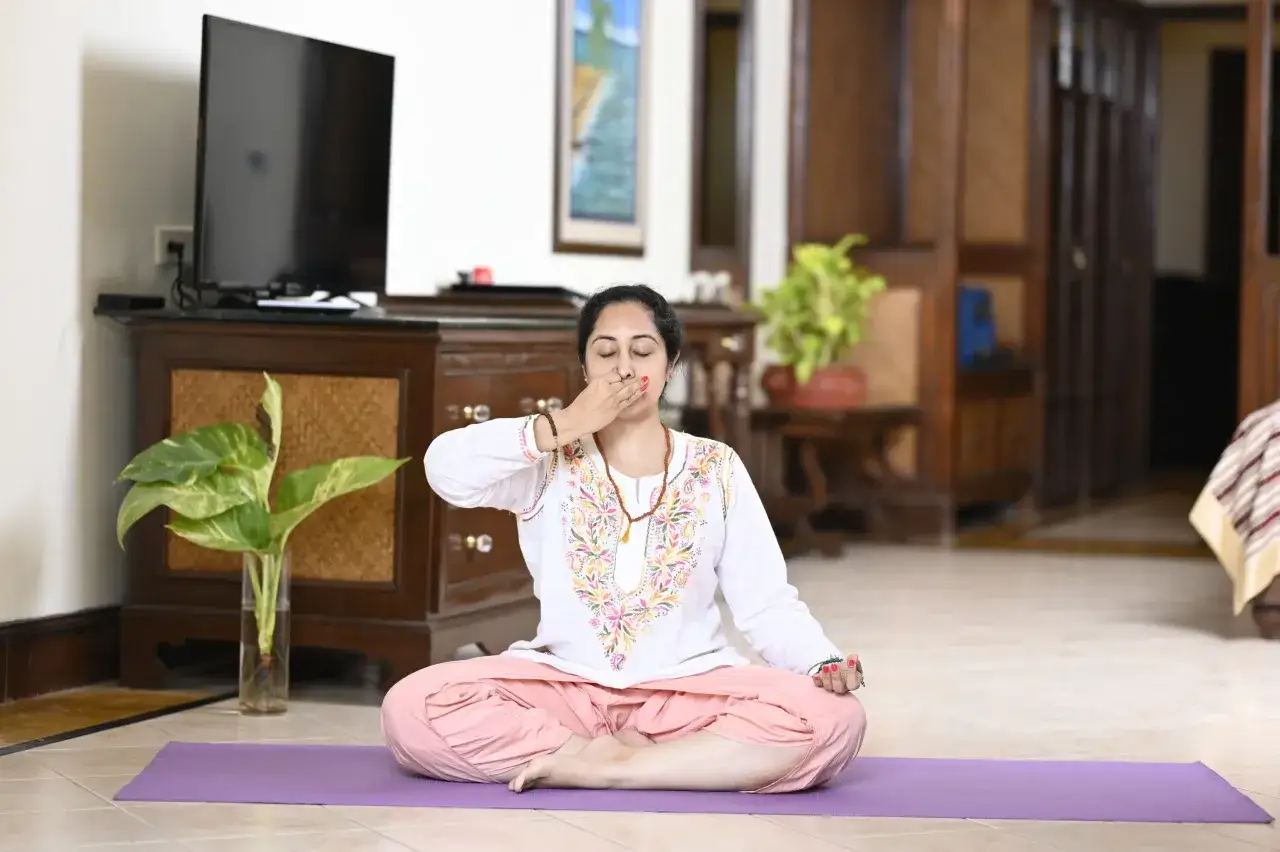 Une femme pratique la respiration pranayama, une excellente raison pourquoi pratiquer le yoga pour trouver la paix intérieure et l'équilibre.