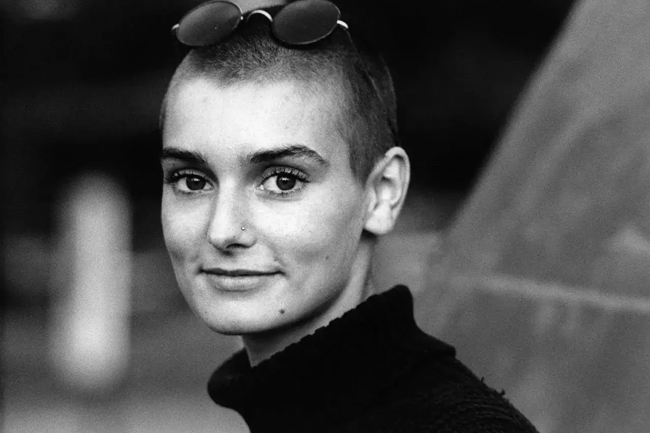 Czarno-białe zdjęcie młodej kobiety z ogoloną głową i okularami na czubku. Jej spojrzenie mówi, że nic nie porówna się do Ciebie.