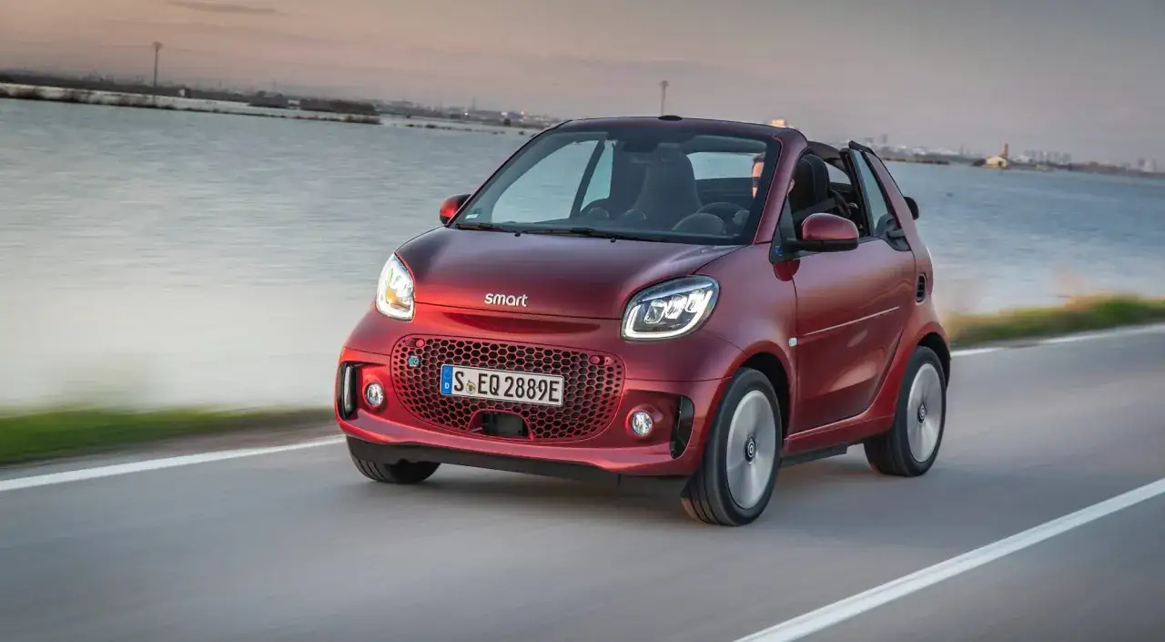 El Smart Fortwo es el coche m&aacute;s peque&ntilde;o del mercado, un &aacute;gil descapotable rojo circulando por una carretera costera.