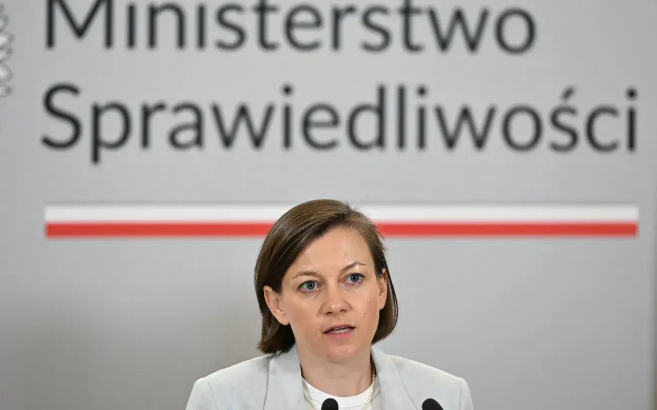 Kobieta przemawia na tle napisu