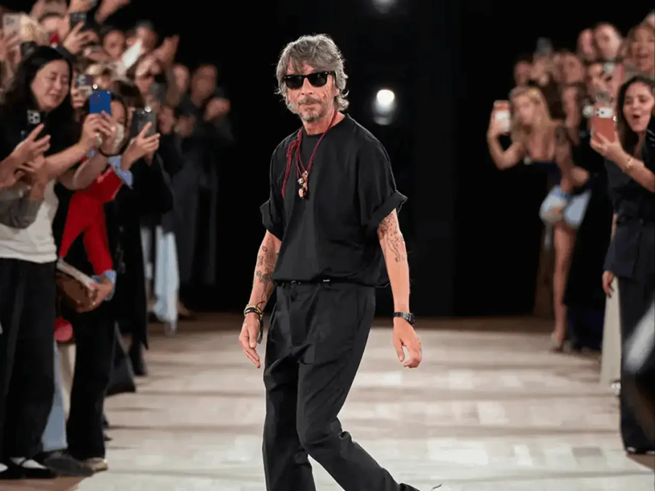 Pierpaolo Piccioli, con gafas de sol y look total black, camina por la pasarela mientras el público graba con sus móviles.
