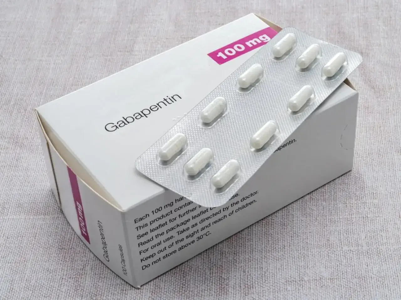 Opakowanie leku Gabapentin 100 mg z blistrem białych kapsułek.