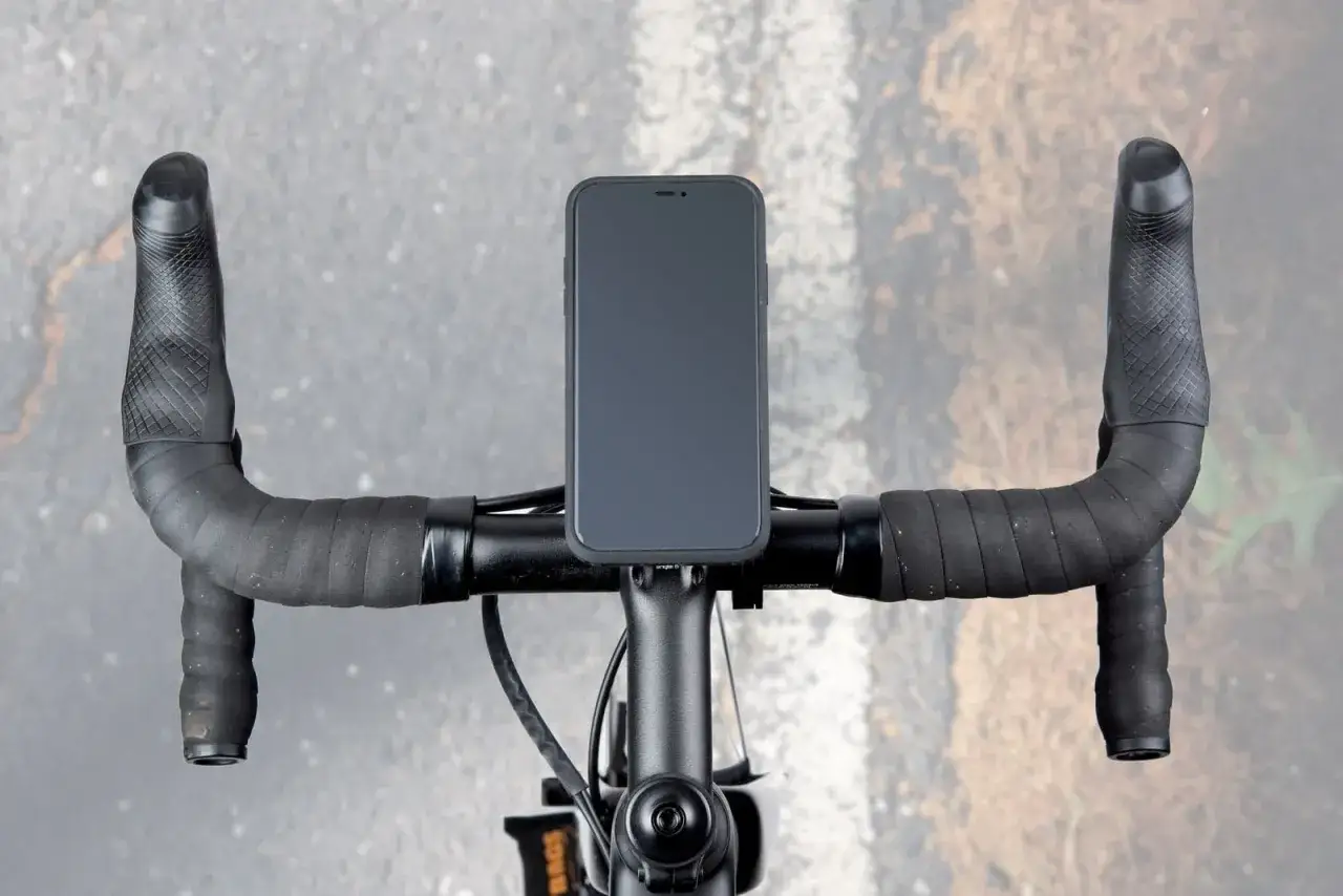 Kawałki starej dętki rowerowej i telefon przymocowany do kierownicy