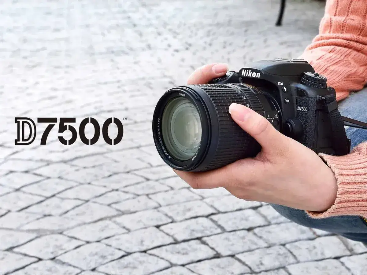 Mani che impugnano una Nikon D7500, pronta per un tutorial italiano.