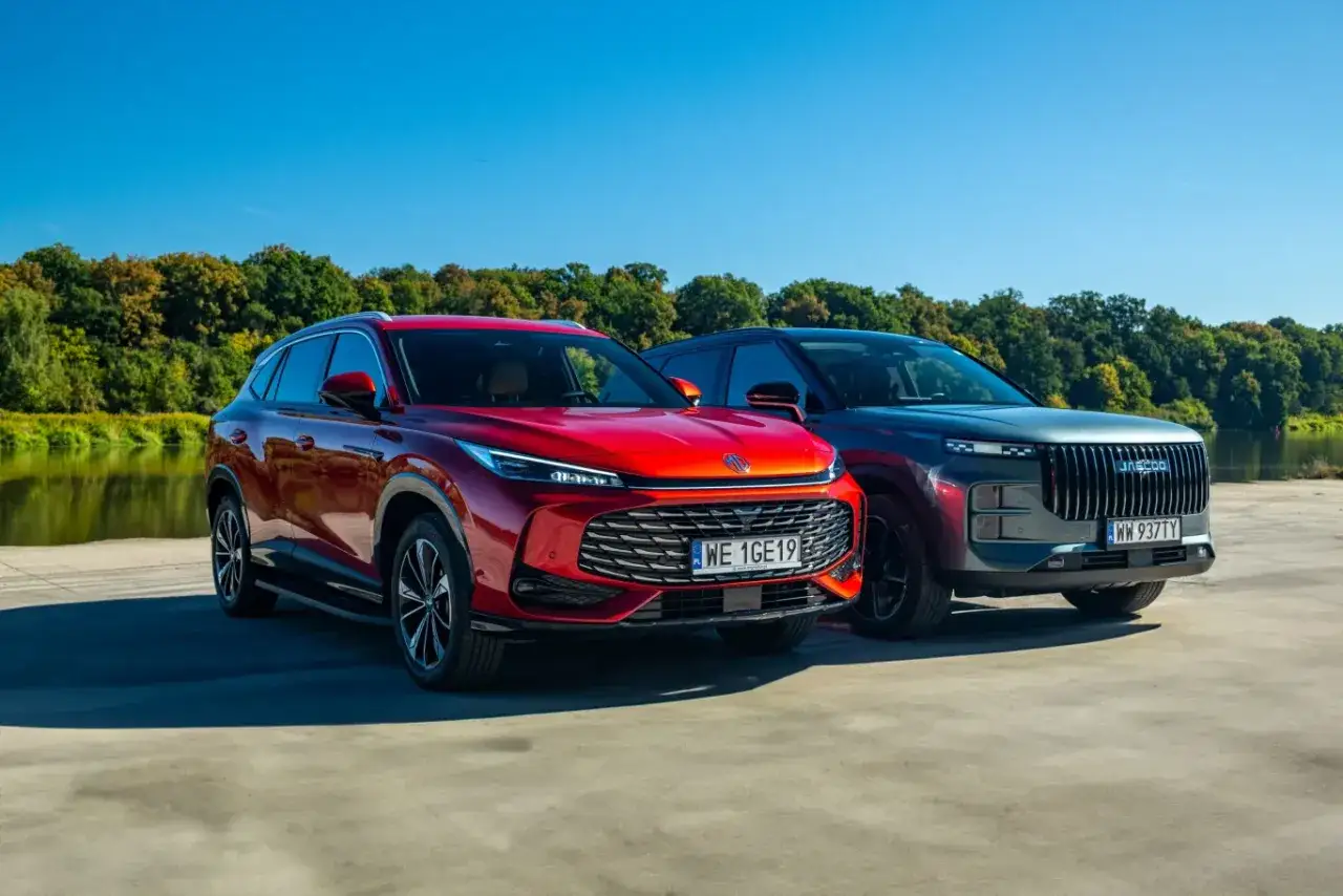 Dwa nowe SUV-y, czerwony i grafitowy, stoją obok siebie. Zastanawiasz się, dlaczego nie warto kupować nowego samochodu? Może warto rozważyć używany?