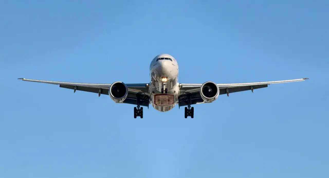 Samolot pasażerski z wysuniętym podwoziem zbliża się do lądowania. Te enter air samoloty to symbol podróży.