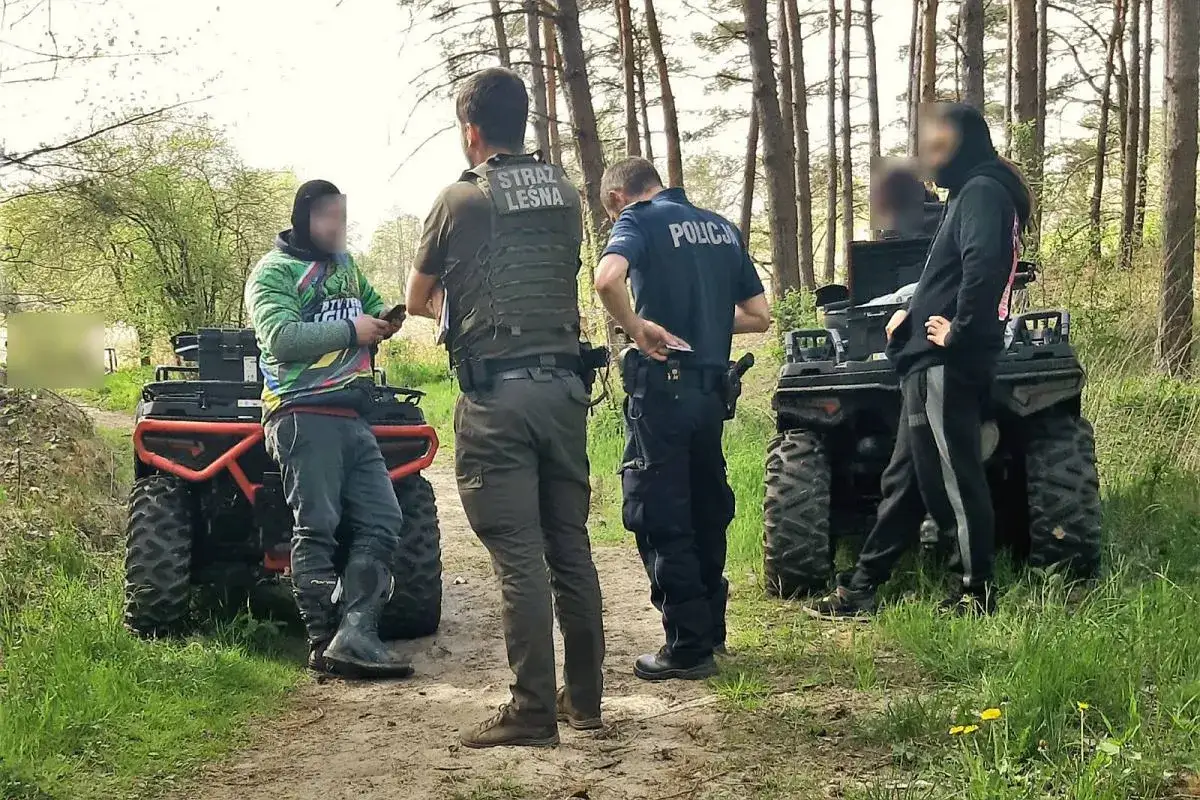 Straż leśna i policja kontrolują, czy quadem można jeździć po lesie. Dwóch funkcjonariuszy i dwóch cywilów stoi przy pojazdach terenowych.