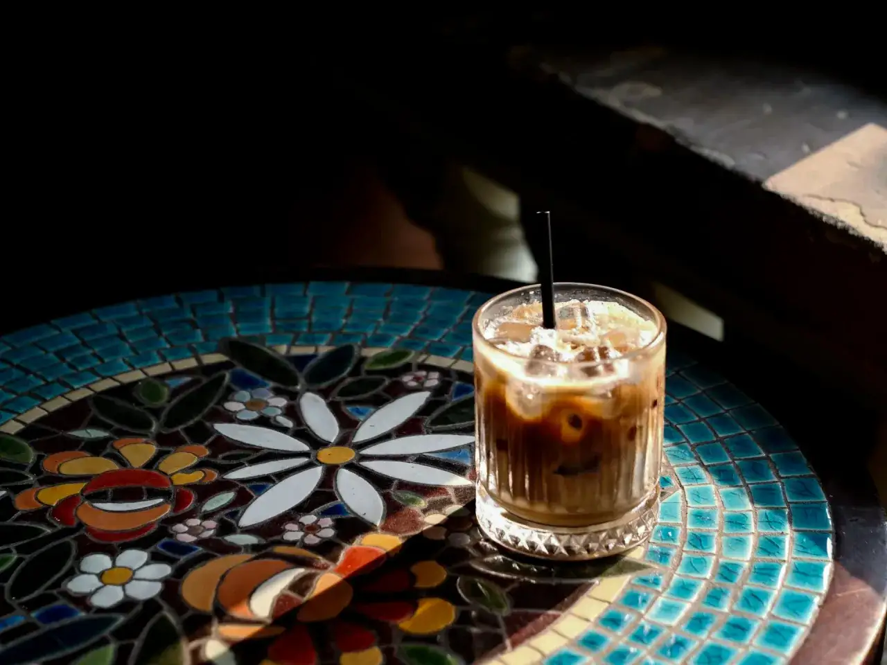 Orzeźwiający cold brew aeropress na mozaikowym stoliku, skąpany w słońcu.