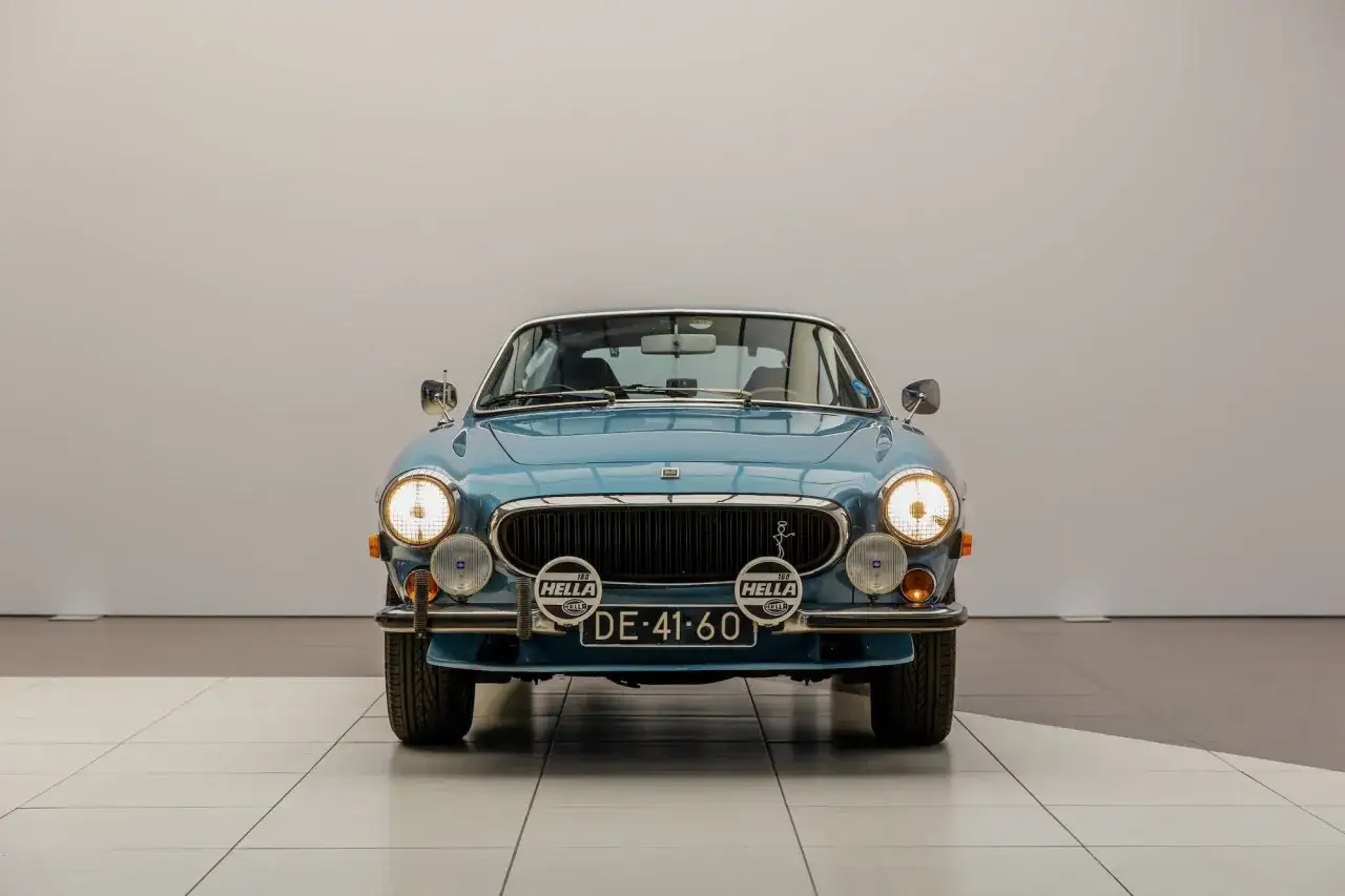 Bl&aring; Volvo P1800, liknande den som k&ouml;rdes av Irv Gordon, med extraljus och registreringsskylten DE-41-60.