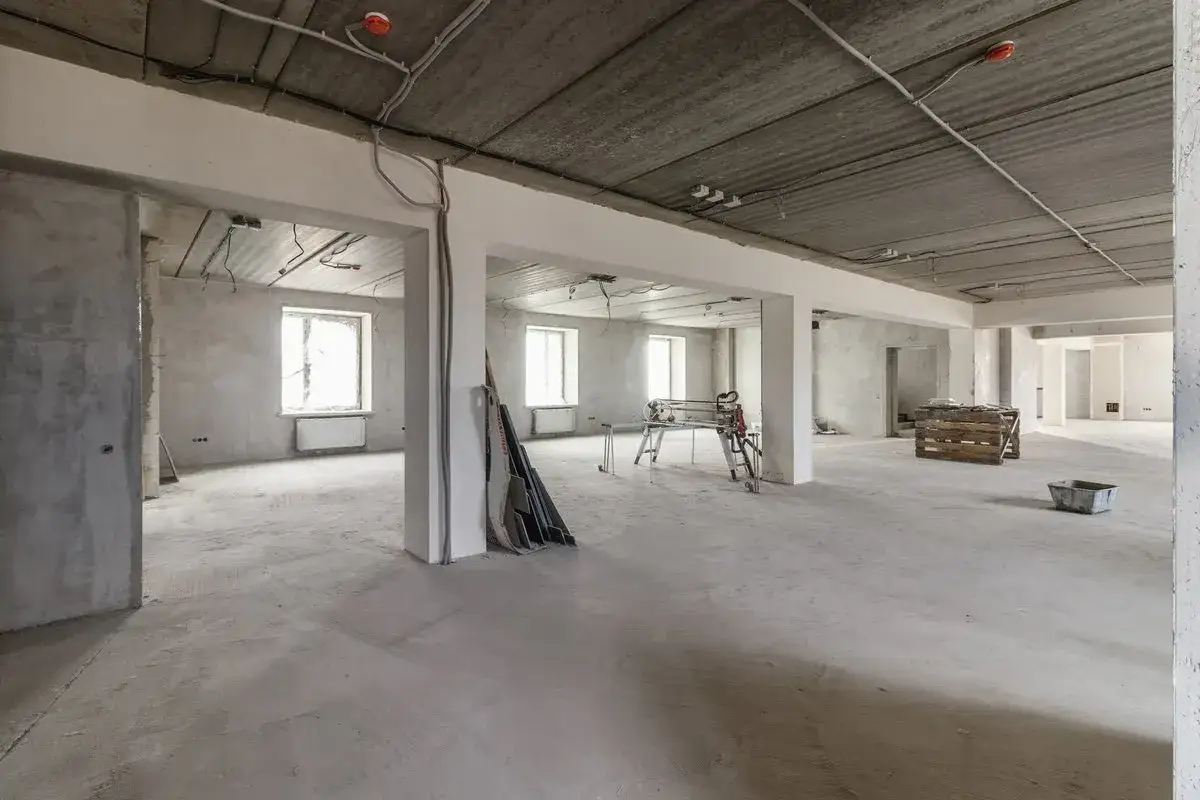 Rohbau eines ehemaligen Geschäftsraums, bereit für die Umnutzung Gewerbe zu Wohnraum. Betonböden, Wände und Decken mit sichtbarer Elektrik.