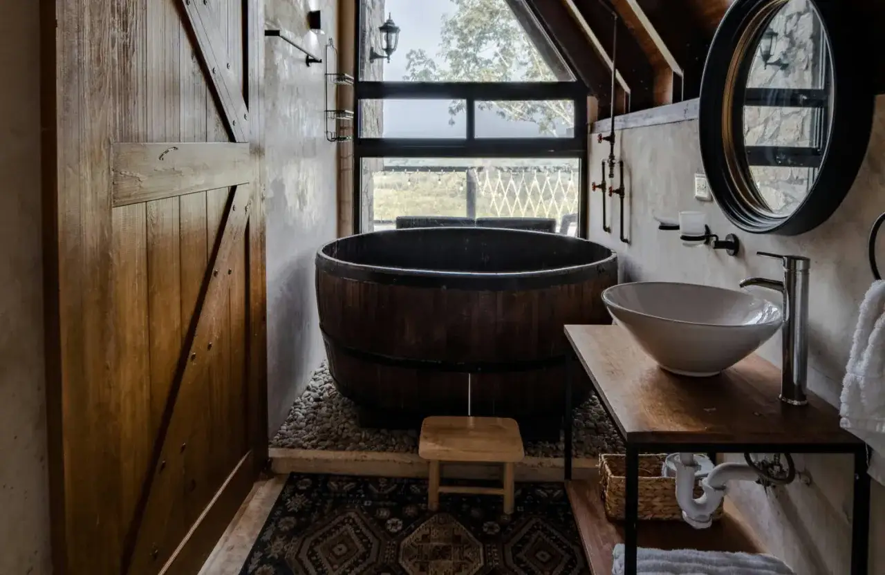 Bain en bois rustique, lavabo moderne et porte coulissante en bois. Une **inspiration salle de bain** naturelle et chaleureuse.