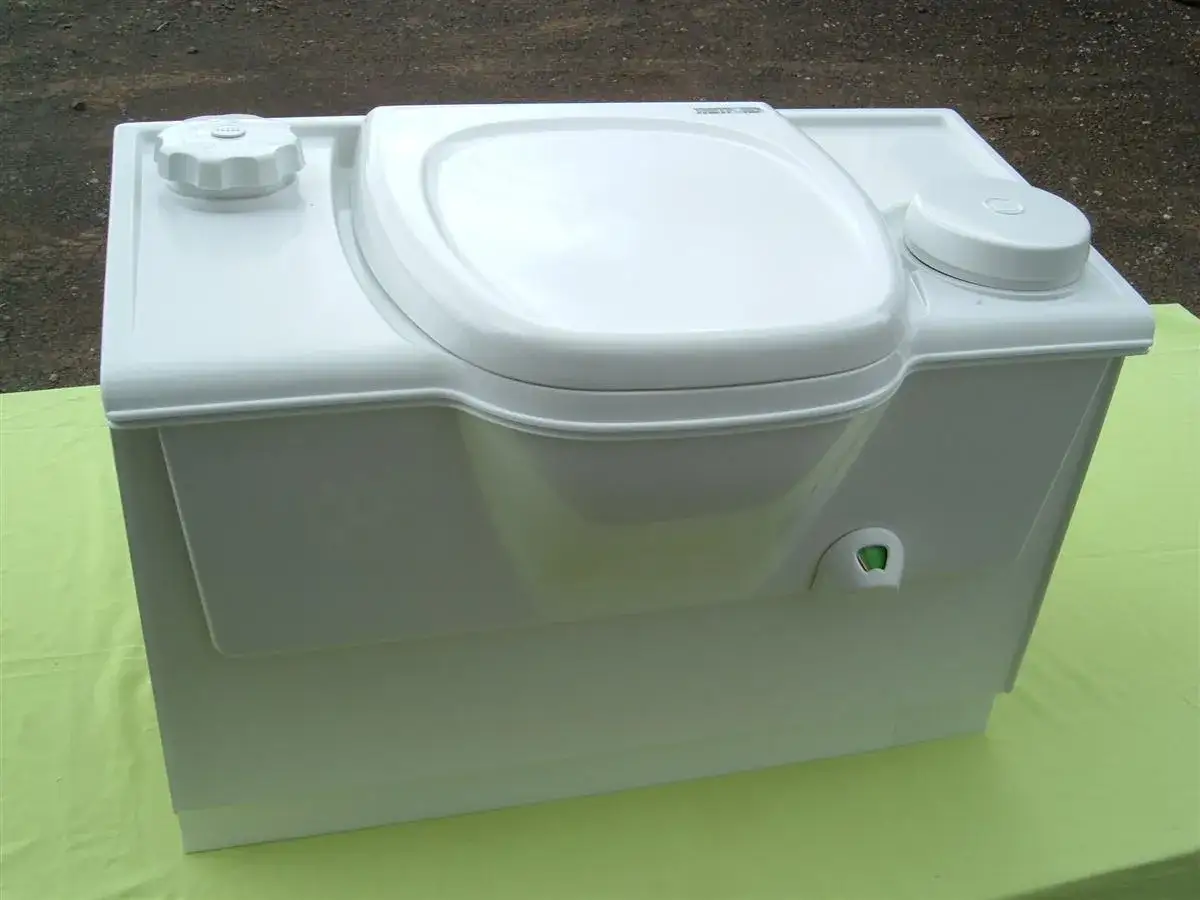 Inodoro portátil blanco con tapa y dos depósitos. Aquí se explica como funciona un poti para viajes.