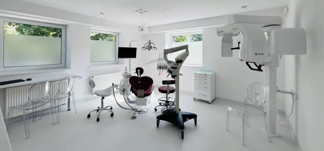 Nowoczesny gabinet stomatologiczny z fotelem, mikroskopem i aparatem RTG.