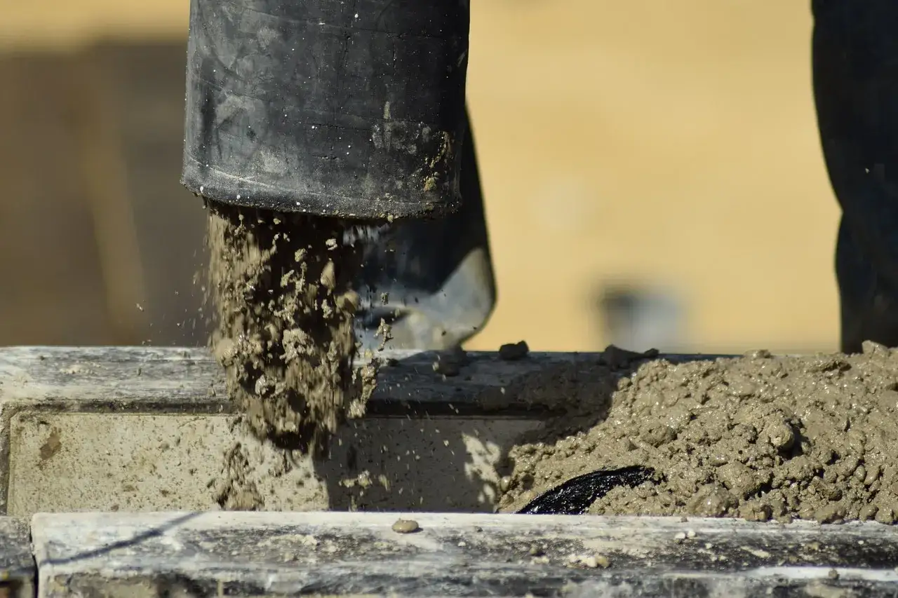 Beton leje się z rury, tworząc mokrą masę. Ważne jest, do jakiej temperatury można lać beton, by zapewnić jego trwałość.