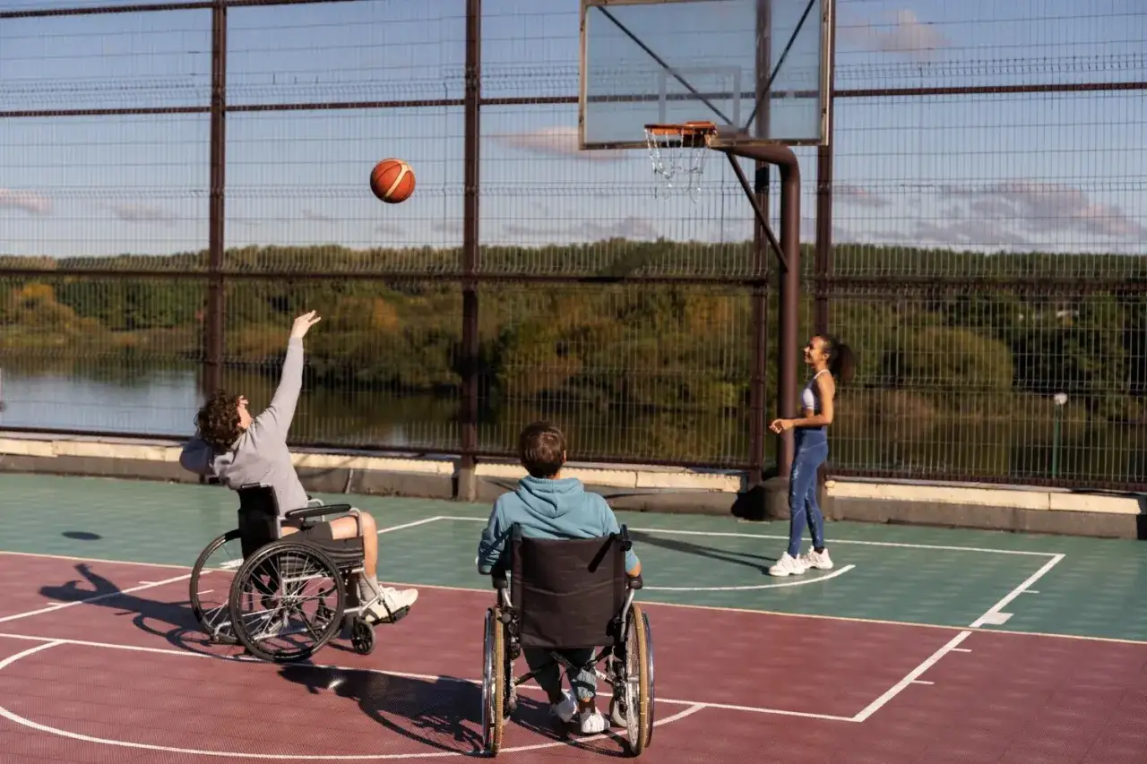 Ragazzi in carrozzina giocano a basket, dimostrando che la disabilit&agrave; motoria non ferma la passione per lo sport.