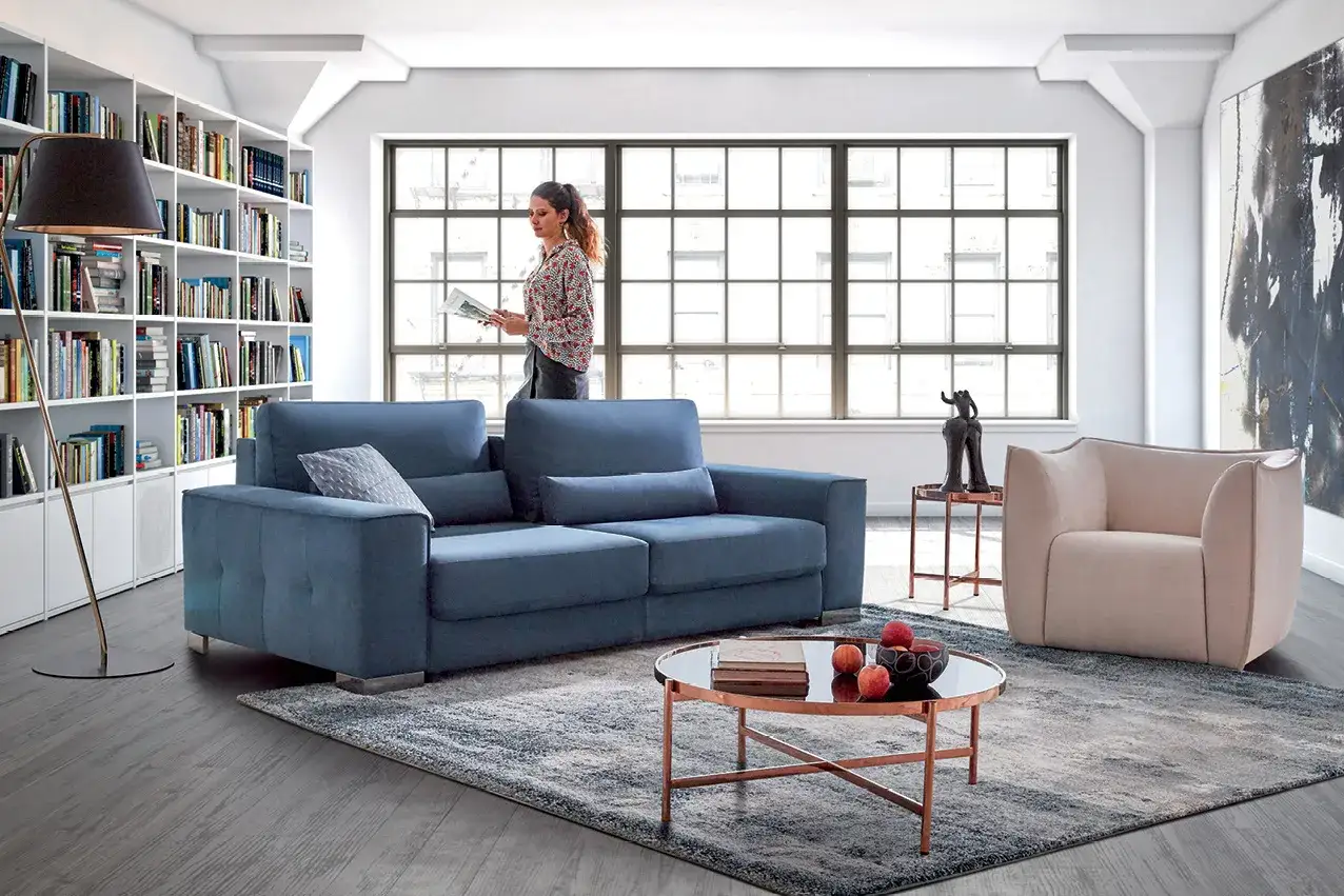 Un salon moderne avec un canapé bleu profond. Quelle couleur de canapé choisir ? Ce bleu est une option audacieuse et élégante.