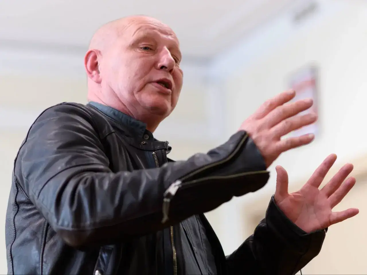 Krzysztof Jackowski w skórzanej kurtce, gestykulując, opowiada o swoich najnowszych przepowiedniach.