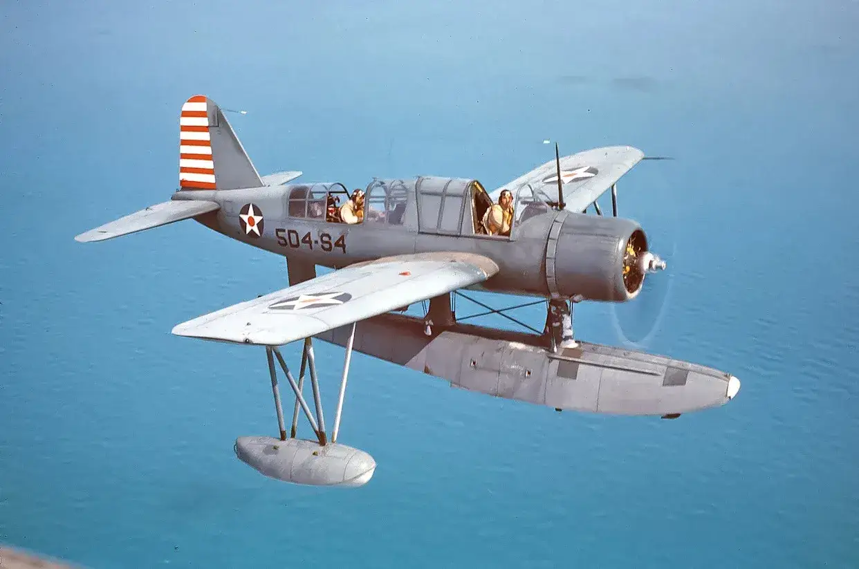 Ein Marchetti-Flugzeug mit zwei Piloten fliegt &uuml;ber das Meer.