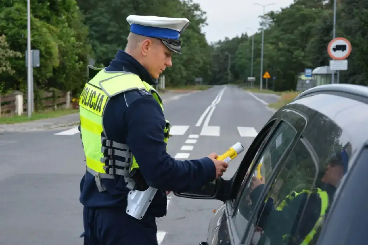 Policjant kontroluje kierowcę, kt&oacute;ry popełnił wykroczenie, np. jazda z zatrzymanym dowodem rejestracyjnym.