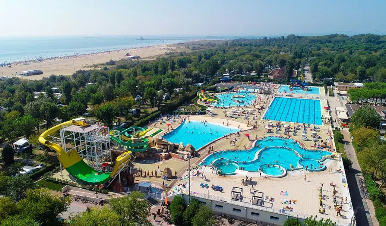 Wodne szaleństwo na **Marina di Venezia camping**! Mnóstwo basenów, zjeżdżalni i plaża w tle. Idealne miejsce na wakacje.