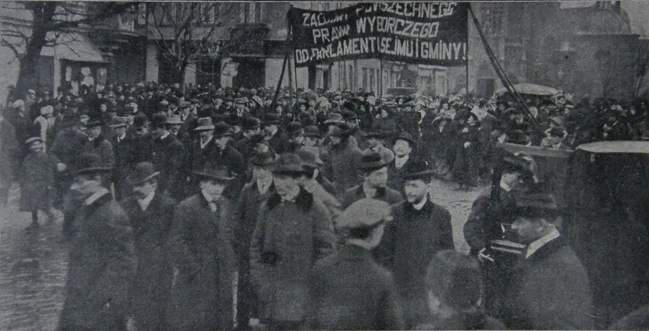 Tłum ludzi na ulicy, transparenty wzywające do praw wyborczych. To obraz walki o emancypację kobiet i ich prawa obywatelskie.