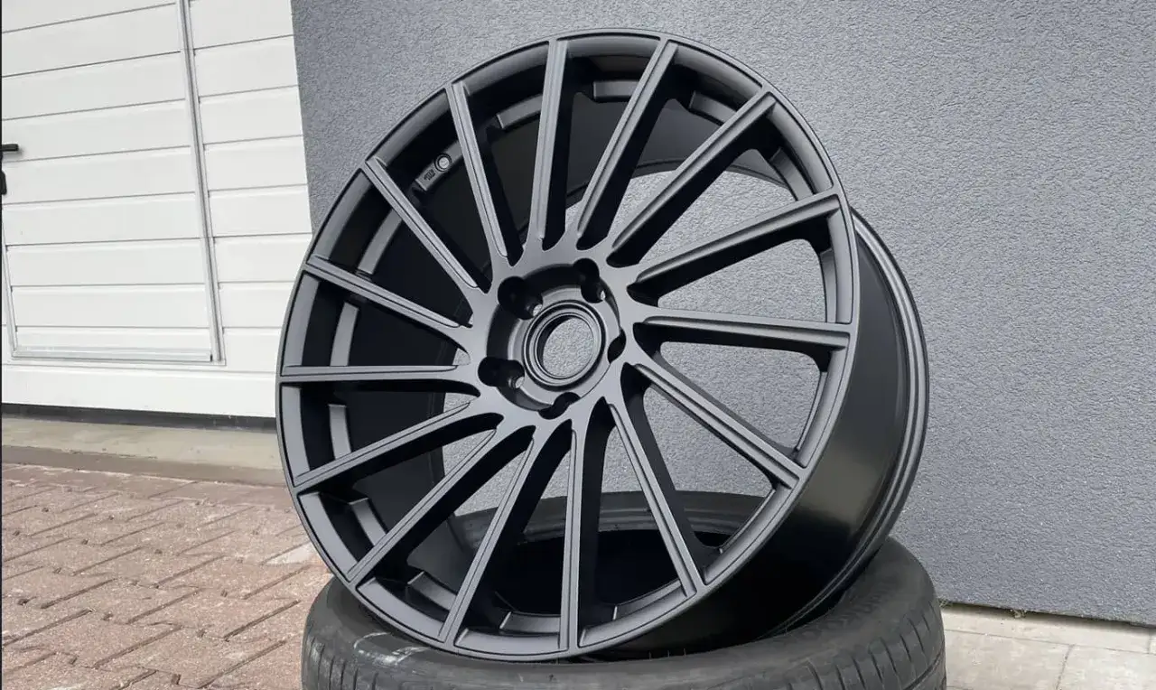 Eleganckie felgi aluminiowe w matowej czerni, kontrastujące z tradycyjnymi felgami stalowymi.
