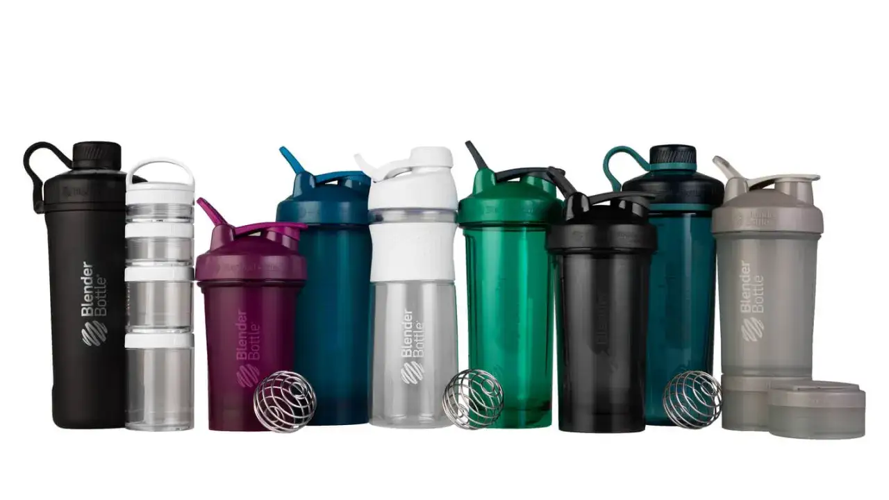 Collection de shakers de diff&eacute;rentes couleurs et tailles, certains avec des compartiments empilables, pr&ecirc;ts &agrave; m&eacute;langer vos boissons.