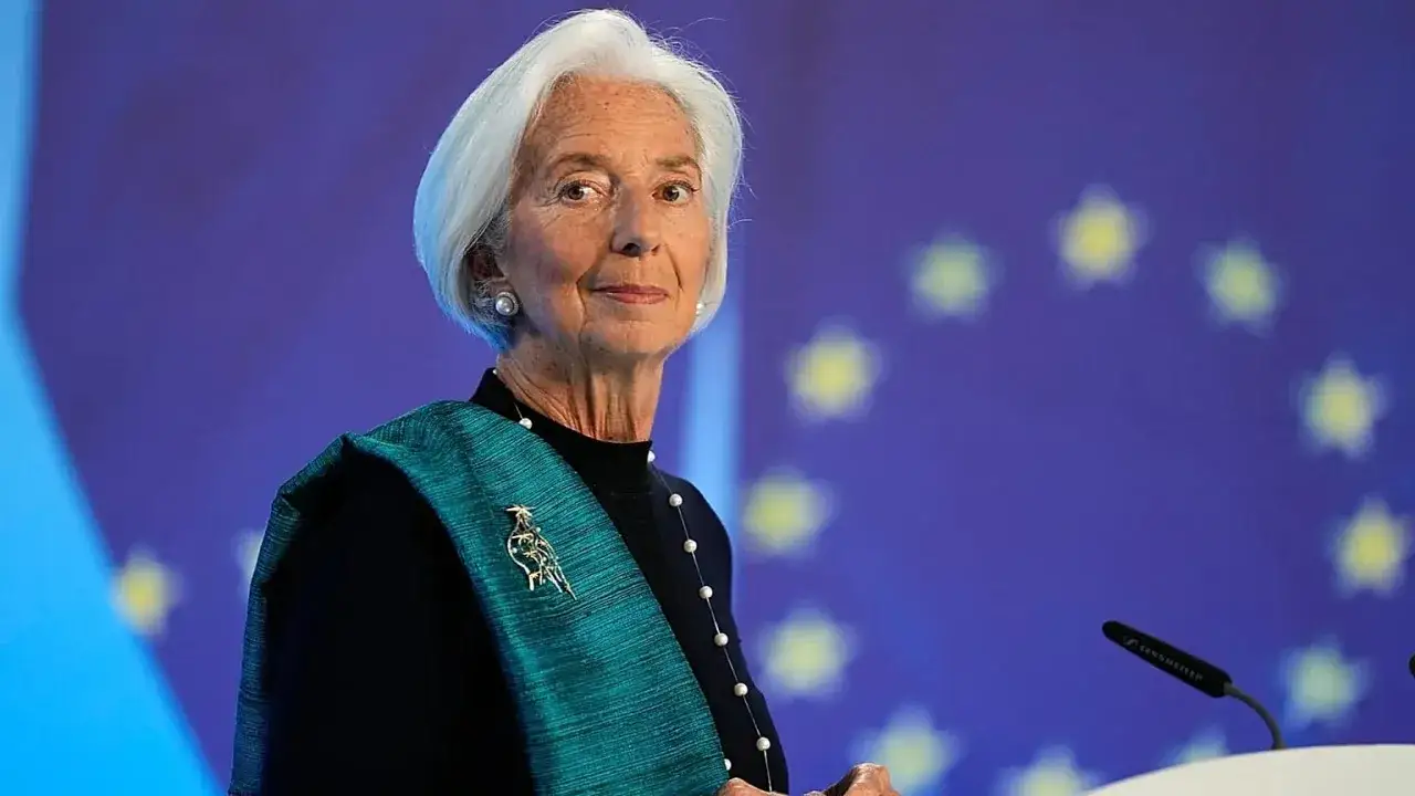 Christine Lagarde spricht &uuml;ber den EZB Zinsentscheid. Im Hintergrund die Europaflagge.