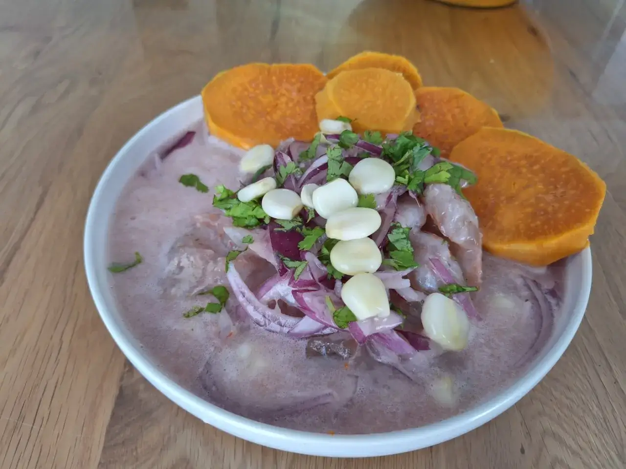 Delicioso ceviche peruano con camarones, cebolla morada, choclo y camote.