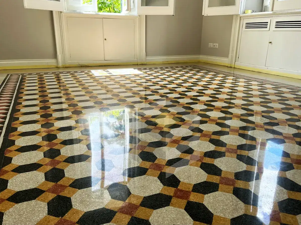 Pavimento in graniglia con disegno geometrico dai colori vivaci, reso brillante dalla lucidatura.