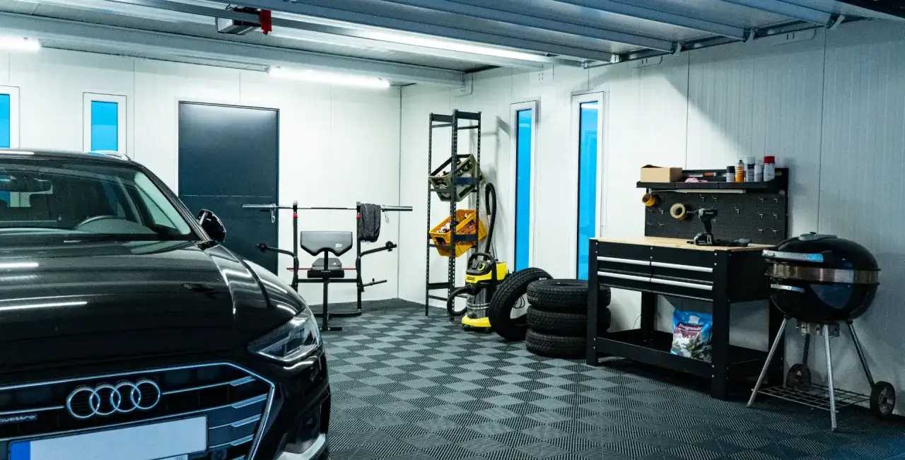 Moderne Garage mit schwarzem Audi, Werkbank, Grill und Fitnessger&auml;ten. Tolle garage gestalten ideen f&uuml;r Ordnung und Funktionalit&auml;t.