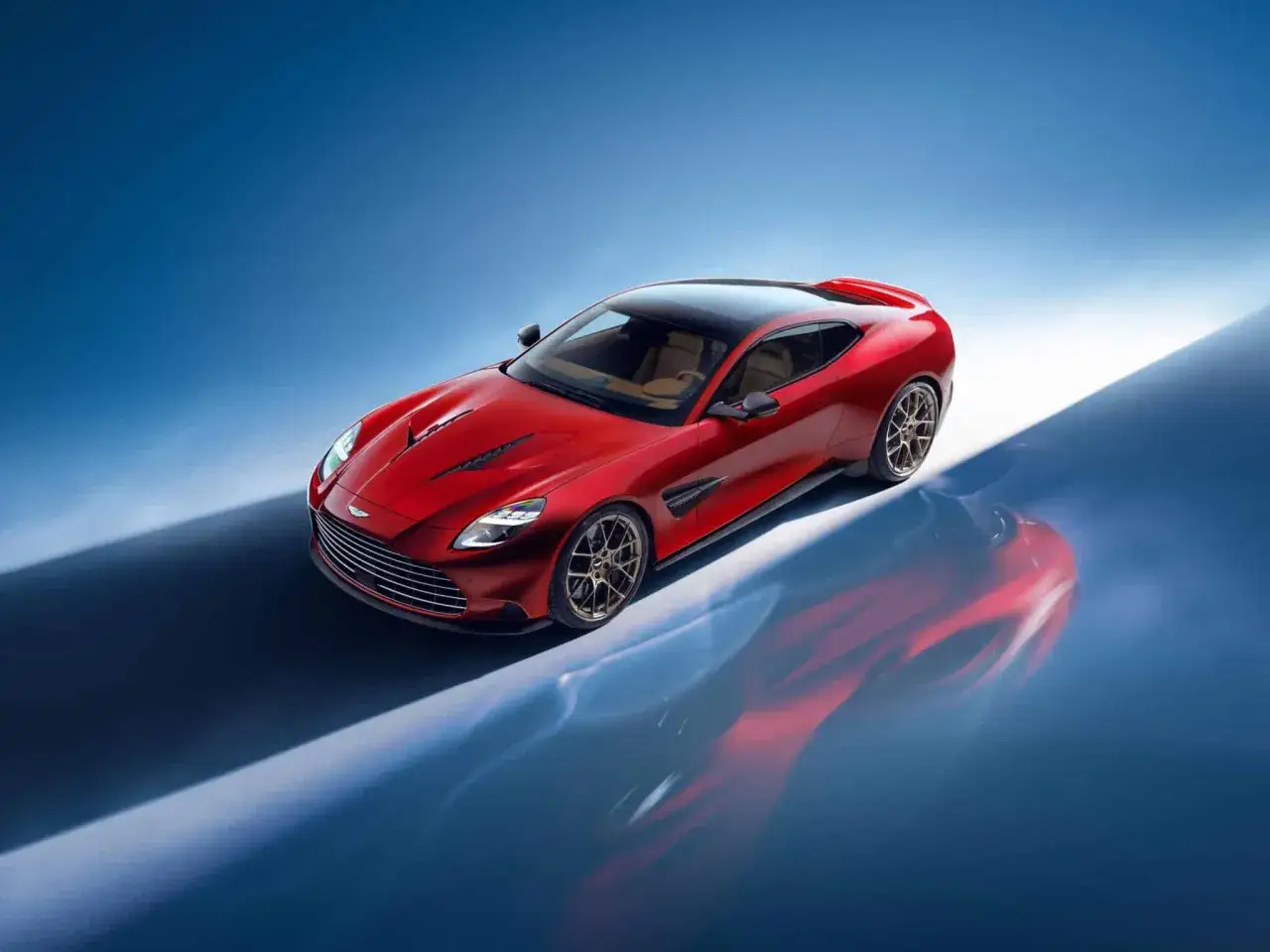 Czerwony Aston Martin Vanquish 2025 z czarnym dachem i beżowym wnętrzem, odbijający się w wodzie.