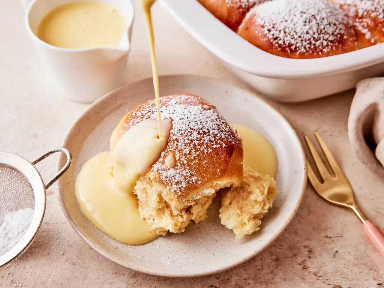 Buchteln nach Omas Rezept, bestäubt mit Puderzucker und übergossen mit warmer Vanillesauce. Ein Genuss!