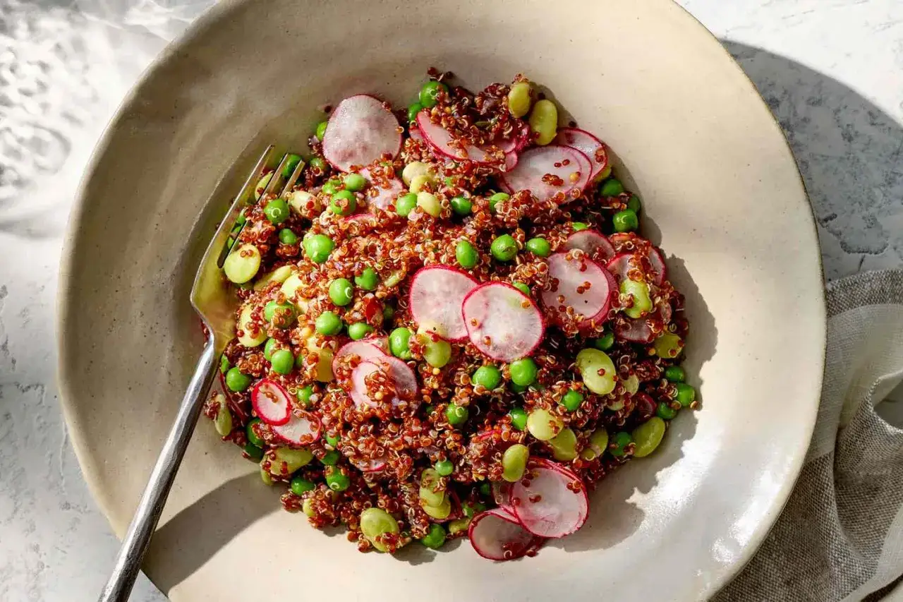 Bunter Quinoasalat mit Erbsen, Edamame und Radieschenscheiben. Eine gesunde Mahlzeit, die zeigt, wie gesund ist quinoa.