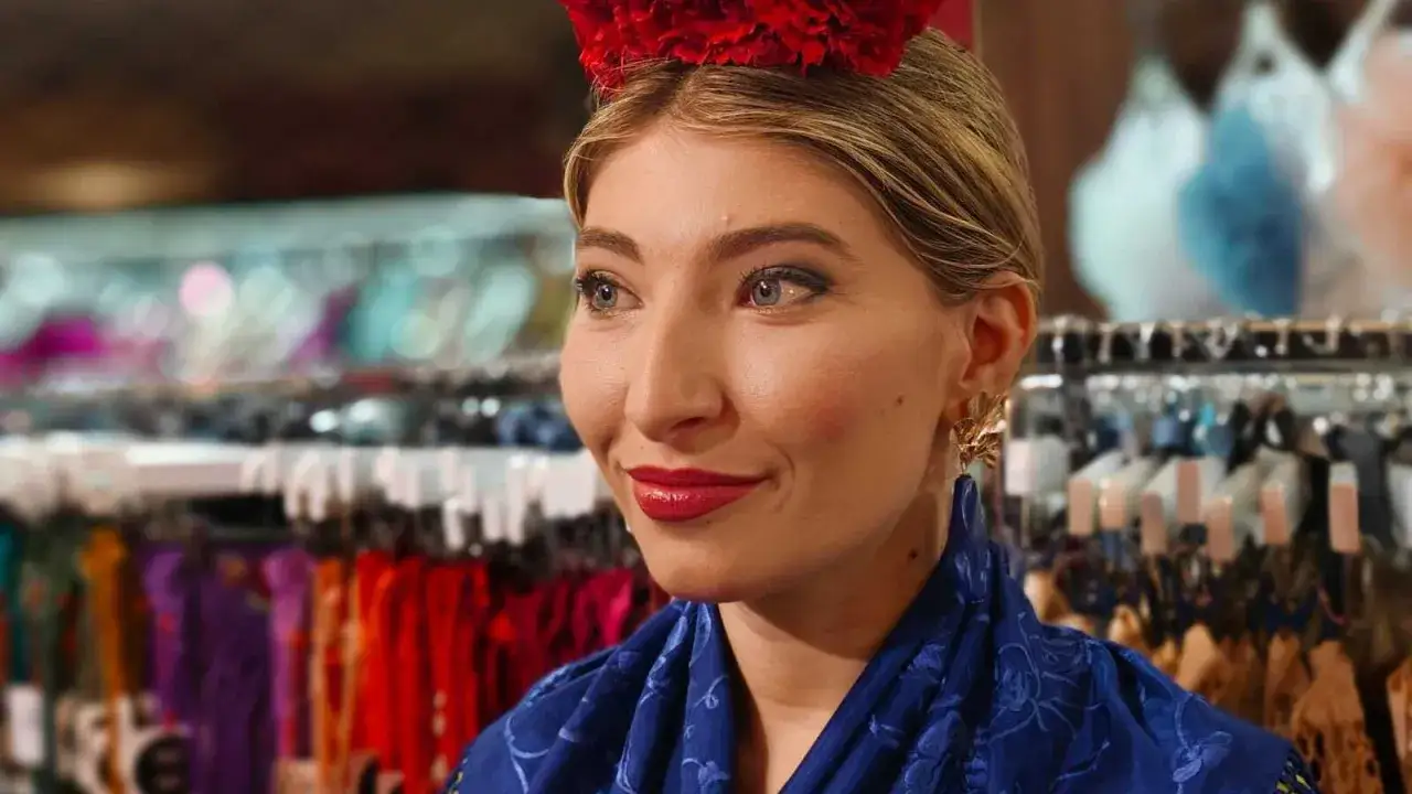 Maquillaje feria de abril: labios rojos, ojos marcados y flor en el pelo.