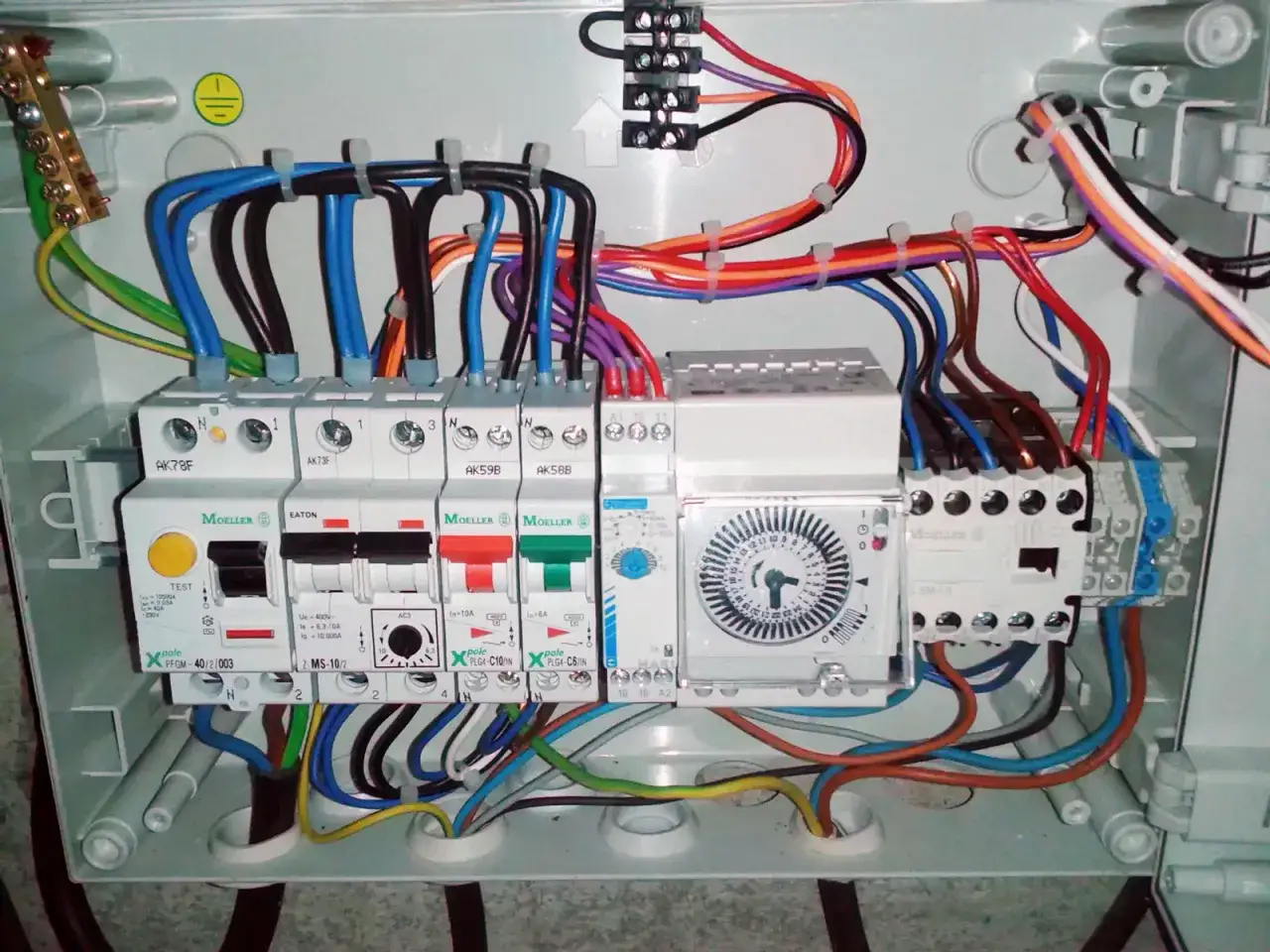 Coffret électrique avec disjoncteurs et programmateur. Un disjoncteur différentiel type A ou AC pour piscine assure la sécurité.