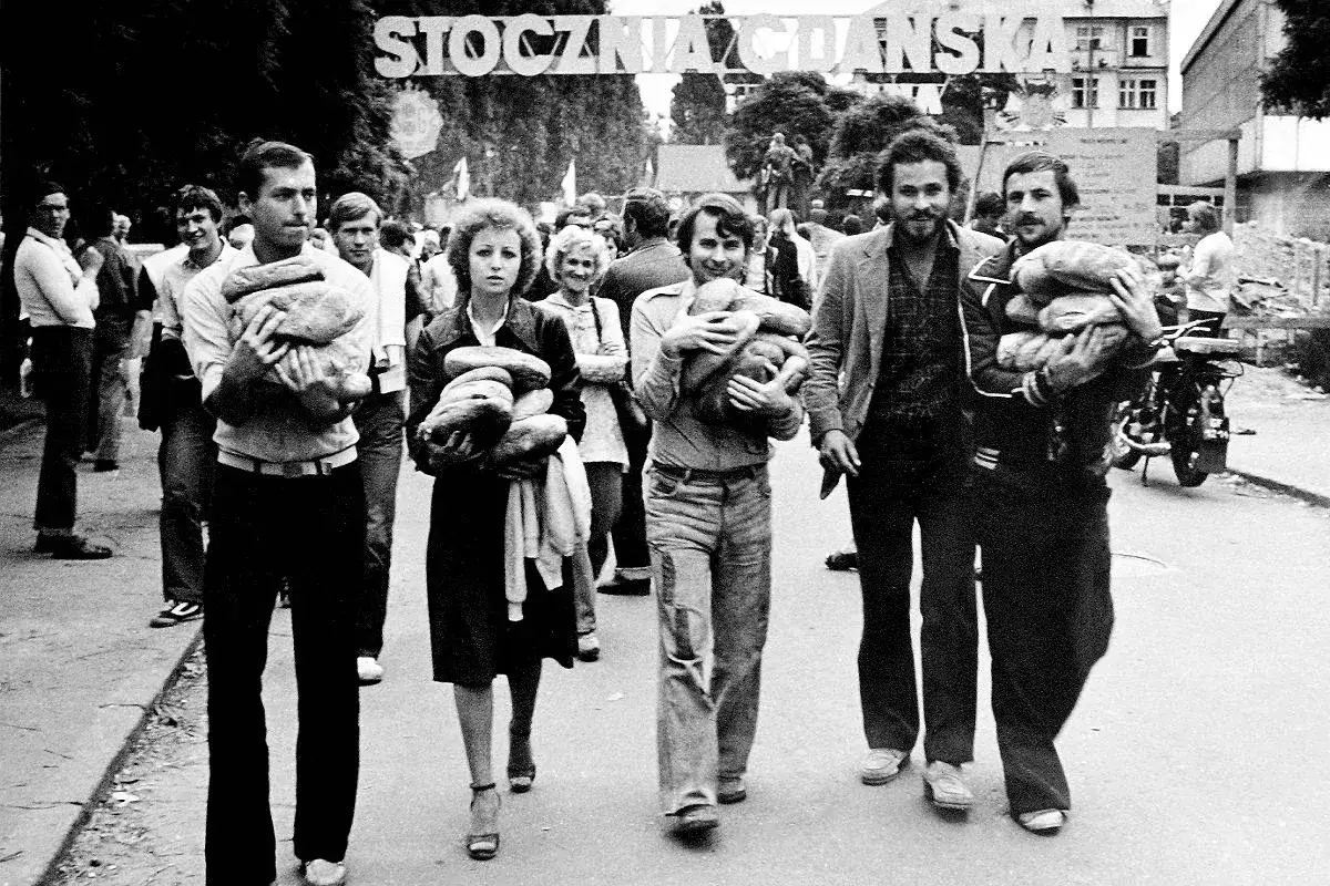 Ludzie niosą chleb podczas strajku w Stoczni Gdańskiej. Solidarność w potrzebie.