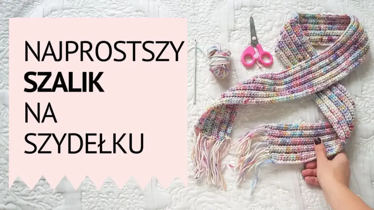 Kolorowy szal na szydełku, gotowy do noszenia. Obok nożyczki i motek włóczki.