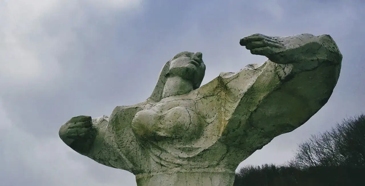 Monumentalna rzeźba kobiety na bulwarze nadmorskim im. Feliksa Nowowiejskiego, z ramionami uniesionymi ku niebu.