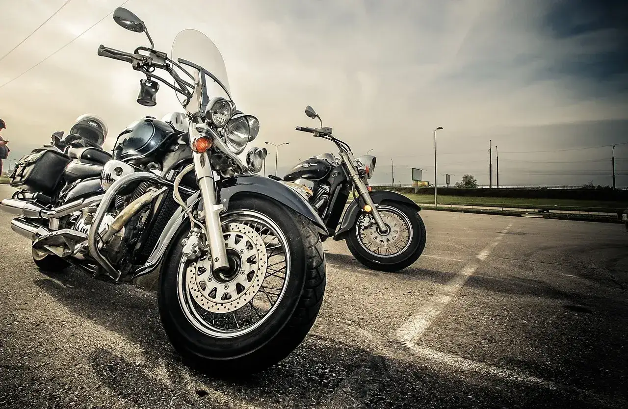 Dwa motocykle, jeden z przodu z chromowanymi elementami i dużą szybą, drugi w tle. Idealne maszyny na długie trasy, dobry motor szosowo turystyczny.
