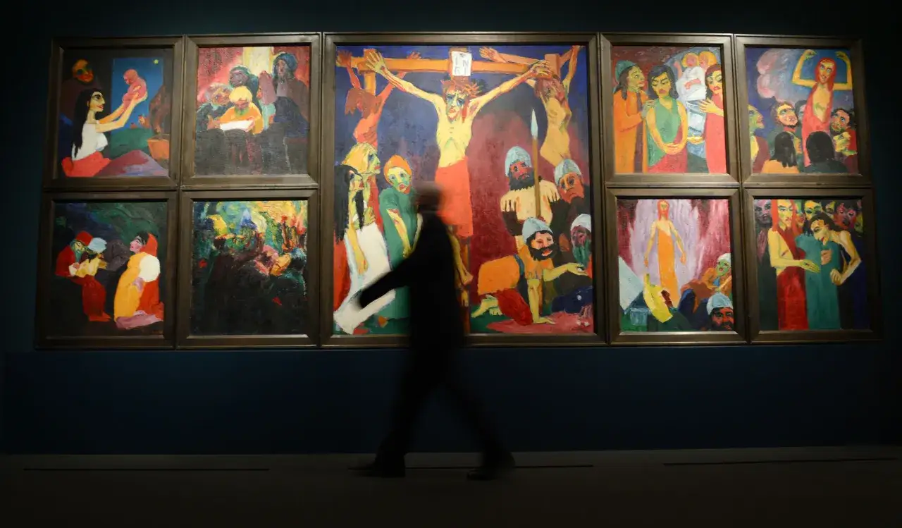Un visiteur traverse une galerie d'art, contemplant une série de peintures vibrantes dans le style de l'expressionnisme allemand.